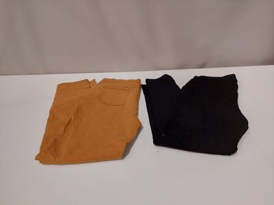 deux paires de pantalons noirs et marron posées sur une surface blanche