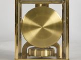 an image of a golden clock sitting on top of a white table
