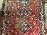 rug on the floor in the corner of a room with a cat on the floor