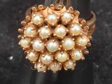 a close up of a ring with pearls on it