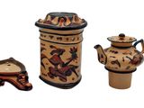 three pieces of pottery that are sitting on a white surface
