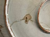 a white bowl with a hole in it that has a crack in it