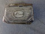 an old silver cigarette case sitting on a blue cloth