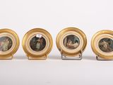 quatre miniatures représentant des personnages, dans des cadres dorés, posées sur une surface blanche