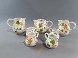 five small vases with flowers on them sitting on a table
