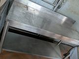 a stainless steel table with a metal shelf underneath it