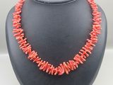 a necklace made of coral coral beads on a black mannequin