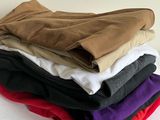 tout un tas de t-shirts de différentes couleurs empilés les uns sur les autres