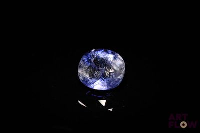 a close up of a blue sapphire on a black surface