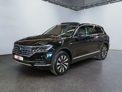 une Volkswagen Touareg noire garée dans un showroom