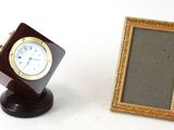 a small picture frame next to a small clock on a stand