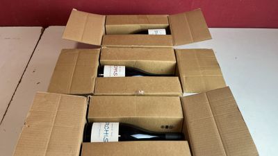 plusieurs bouteilles de vin se trouvent dans un carton sur une table