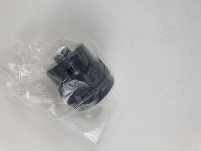 un objet noir dans un sac en plastique posé sur une surface blanche