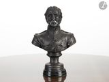 statue of a bust of a man on a pedestal on a table