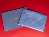 a pair of blue envelopes sitting on top of a red surface
