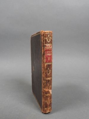 an old book sitting on top of a table next to a gray background