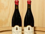 deux bouteilles de vin posées sur un tonneau