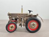 a model of a tractor with red wheels on a table