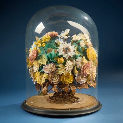 une cloche en verre contenant un bouquet de fleurs