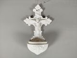 une croix blanche accrochée au mur, avec une fleur à l'intérieur
