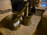 deux mortiers posés sur une table en pierre près d'une cheminée