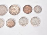 several different coins are arranged in a row on a white surface