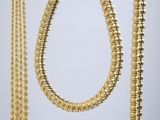 un ensemble composé d'un collier, d'un bracelet et d'une broche en or
