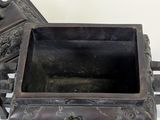 a small metal box sitting on a table next to a chair