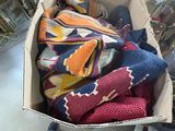 a box full of sweaters and mittens sitting on the floor