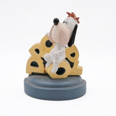 the figurine is sitting on top of a piece of cheese