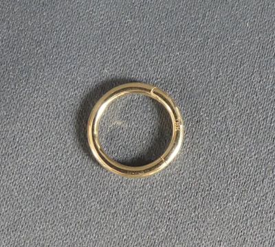 gros plan d'une bague en or sur une surface grise