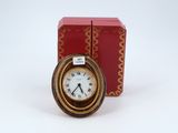 a small clock sitting next to a red box