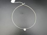 un collier en argent orné d'une perle blanche sur un fond noir