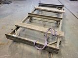 a wooden bed frame that has a purple strap on it