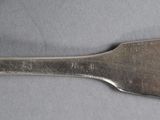 a silver spoon with a metal handle on a table
