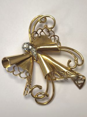 une image représentant une broche en or ornée d'un diamant au centre