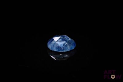 a close up of a blue diamond on a black surface