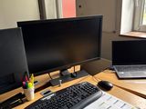 a desk with two computers and a laptop on it