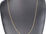 a gold chain necklace on a mannequin neck