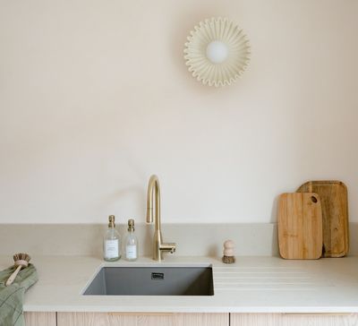 a kitchen with a sink, cutting board, and cutting board on the counter