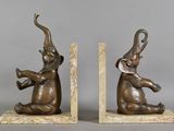 pair of bronze elephants on marble bookends on grey background