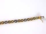 an image of a close up of a metal bracelet on a white surface
