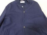 a blue jacket sitting on top of a table next to a white wall