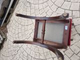 a wooden chair that is sitting on a brick floor