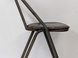 the chair is made of metal and has a leather seat