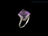 a close up of a ring with a purple stone on it