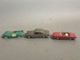 three toy cars sitting next to each other on a table