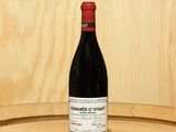 une bouteille de vin posée sur un tonneau