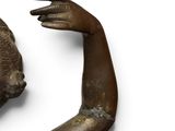 an old bronze statue of a woman ' s head and hands