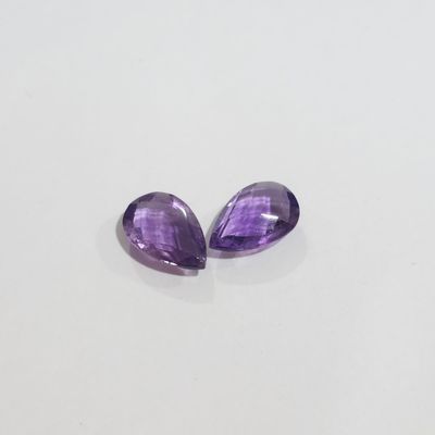 a pair of purple amethtites sitting on top of a white surface